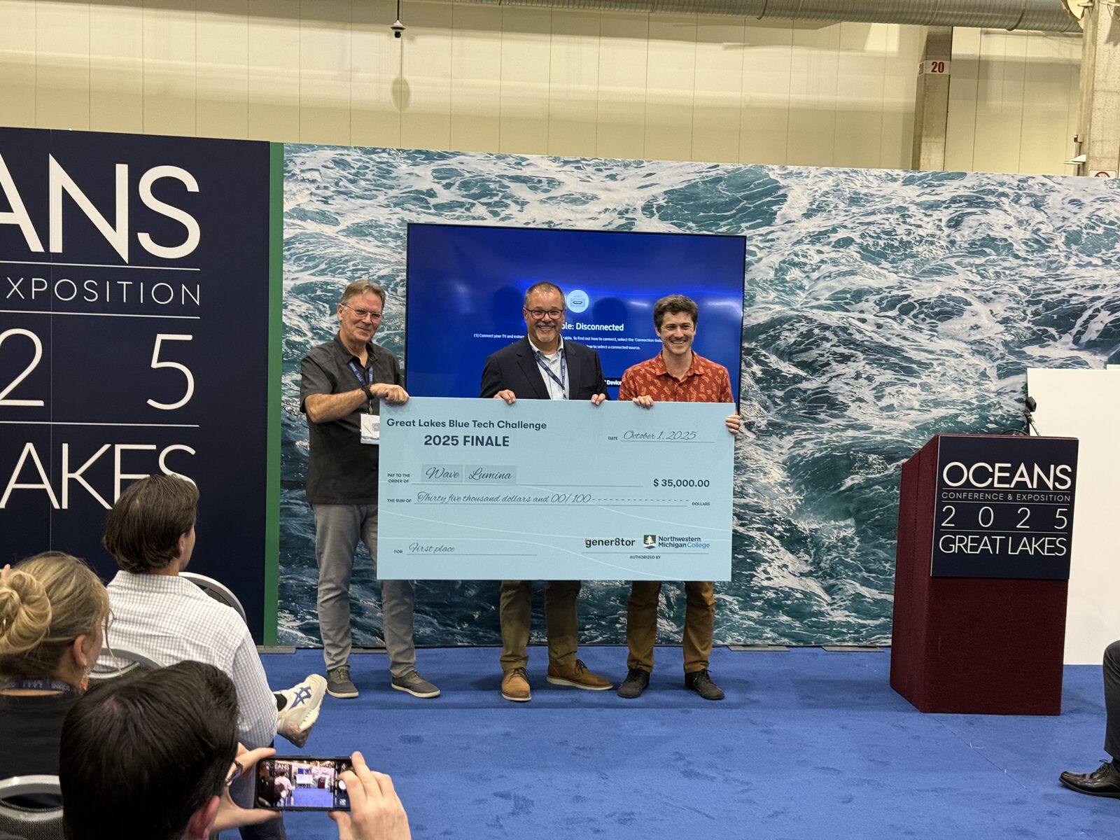 Wave Lumina accepting the $35,000 first-place check at the Great Lakes Blue Tech Challenge finale, OCEANS 2025 in Chicago